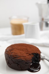 Delicious fresh fondant with hot chocolate served on white table, closeup