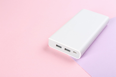Modern external portable charger on color background. Space for text