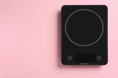Modern digital kitchen scale on pink background, top view. Space for text