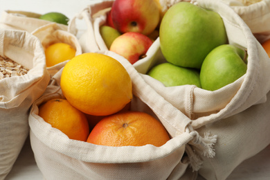 Cotton eco bags with fruits, closeup view