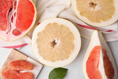 Photo of Different sorts of tasty pomelo fruits on white textured table, flat lay