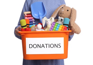 Woman holding donation box full of different toys on white background, closeup