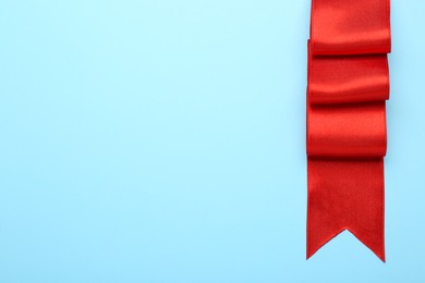 Beautiful red ribbon on light background, top view. Space for text