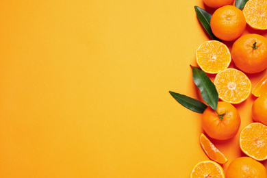 Flat lay composition with fresh ripe tangerines and space for text on orange background. Citrus fruit