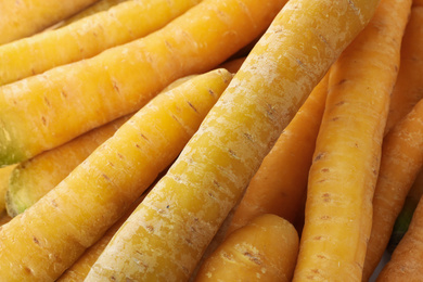 Fresh raw yellow carrots as background, closeup