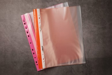 Photo of File folders with punched pockets on grey table, flat lay