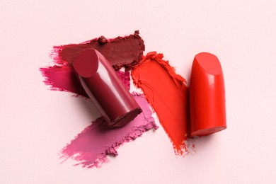 Photo of Different lipsticks and smears on light background, top view