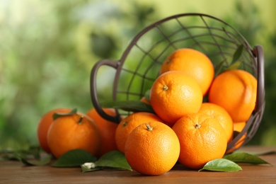 Fresh ripe oranges on wooden table against blurred background. Space for text