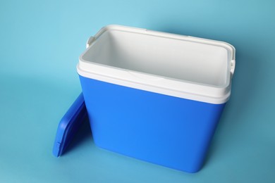 Open blue plastic cool box on turquoise background