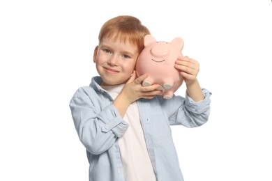 Cute little boy with ceramic piggy bank on white background