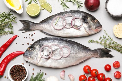 Flat lay composition with fresh raw dorado fish and ingredients on light grey table