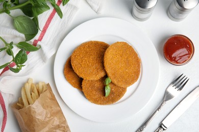 Delicious fried breaded cutlets served on white table, flat lay