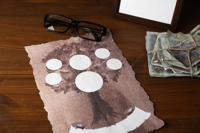Paper with family tree template, photos and glasses on wooden table