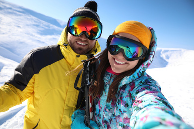 Photo of Couple taking selfie on hill. Winter vacation