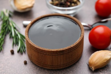 Photo of Organic balsamic vinegar and cooking ingredients on grey table, closeup