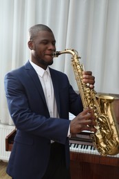 African-American man playing saxophone indoors. Talented musician