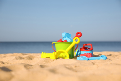 Different child plastic toys on sandy beach
