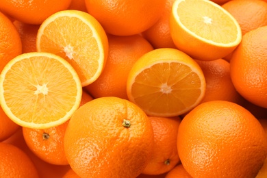 Cut and whole fresh ripe oranges as background, top view