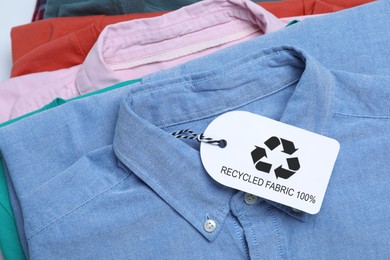 Photo of Different clothes with recycling label, closeup view