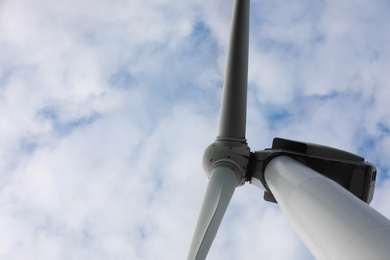 Photo of Wind turbine against cloudy sky, low angle view. Alternative energy source