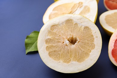 Photo of Different sorts of tasty pomelo fruits on dark blue background, closeup