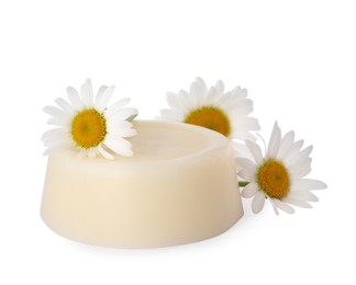 Solid shampoo bar and chamomiles on white background. Hair care