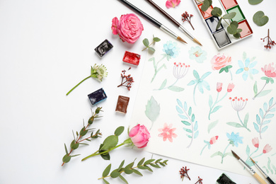 Flat lay composition with watercolor paints and floral picture on white background