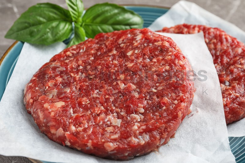 Raw meat cutlets for burger on plate, closeup
