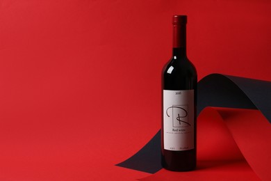 Bottle of delicious red wine on color background, space for text
