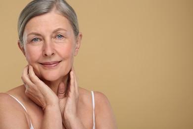 Photo of Portrait of senior woman with aging skin on beige background, space for text. Rejuvenation treatment
