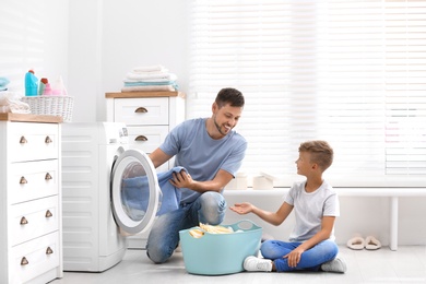 Dad and son doing laundry at home