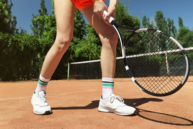 Woman playing tennis on court during sunny day, closeup