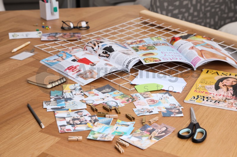Composition with different photos, magazines and metal grid on wooden table indoors. Creating vision board