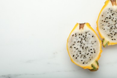 Delicious cut dragon fruit (pitahaya) on white marble table, top view. Space for text
