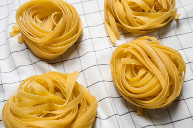 Tagliatelle pasta on white tablecloth, flat lay