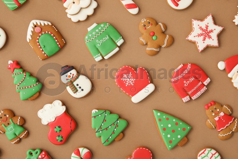 Different Christmas gingerbread cookies on brown background, flat lay