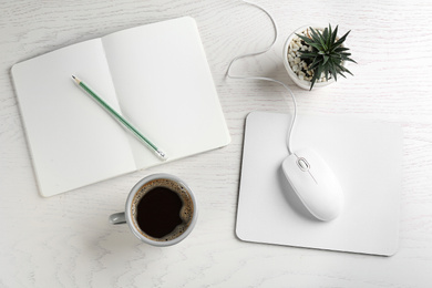 Flat lay composition with mouse and cup of coffee on white wooden table
