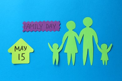 Card with text Family Day and paper cutouts on light blue background, flat lay