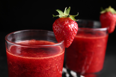 Tasty strawberry smoothie in glass on table, closeup