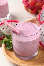 Delicious pitahaya smoothie, mint and fresh fruits on white wooden table, closeup