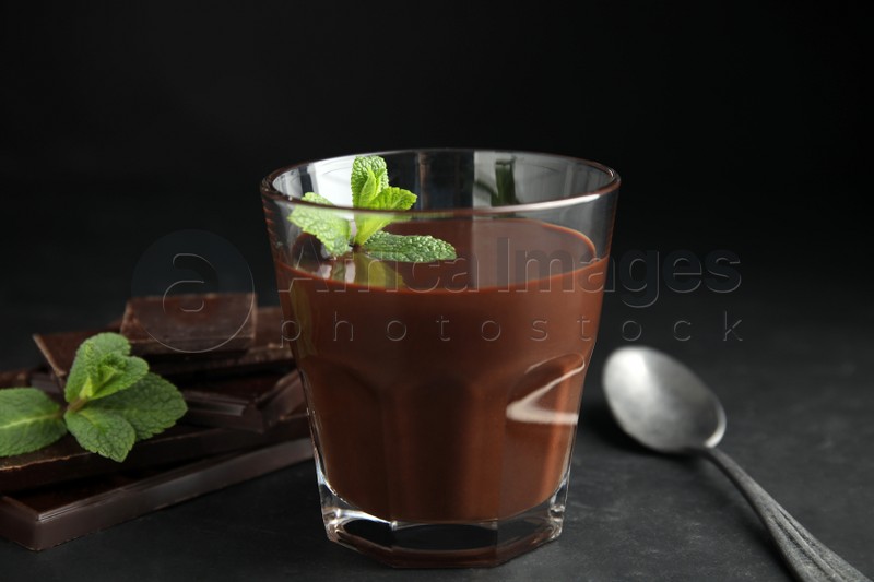 Glass of delicious hot chocolate with mint on dark grey table