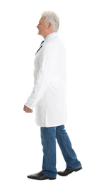 Full length portrait of senior doctor walking on white background