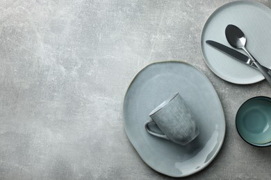 Photo of Stylish empty dishware and cutlery on light grey table, flat lay. Space for text