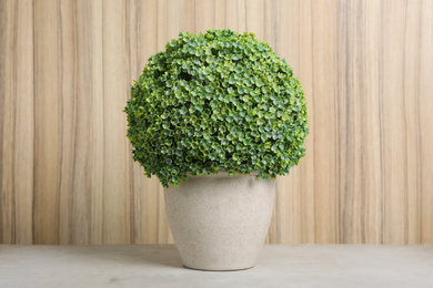 Artificial plant in flower pot on light grey stone table