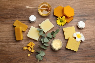 Flat lay composition with beeswax and cosmetic products on wooden table