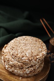 Photo of Stack of crunchy buckwheat cakes on wooden plate, closeup