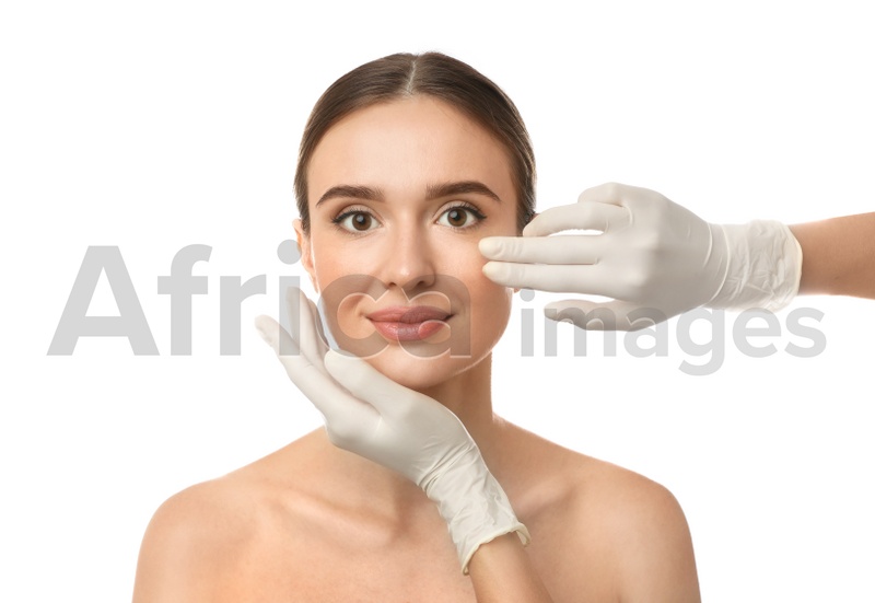 Doctor examining woman's face before plastic surgery on white background