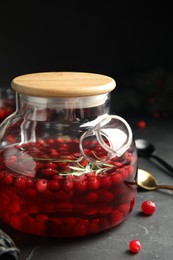 Photo of Tasty hot cranberry tea on black table
