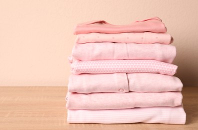 Stack of baby girl's clothes on wooden table