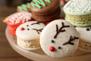 Photo of Beautifully decorated Christmas macarons on dish, closeup